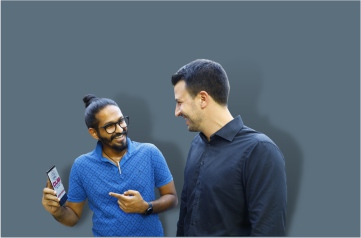 An Executive shows his mobile phone to a guest and explains him about the client city union bank